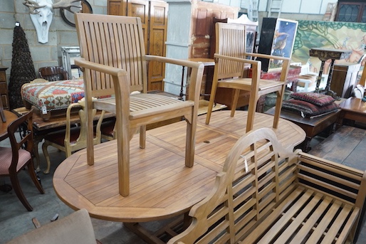 An extending teak garden table, length 140cm extended, width 100cm, height 75cm, a Lutyens style teak garden bench and two elbow chairs with waterproof covers